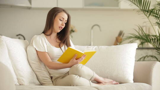女人坐在沙发上看书