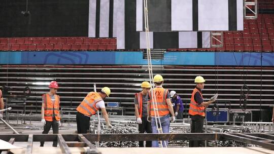 体育场内工人搭建舞台的场景