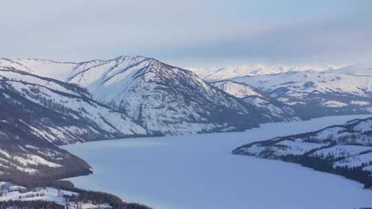 航拍新疆冬季喀纳斯河流晨雾雪山森林雪景