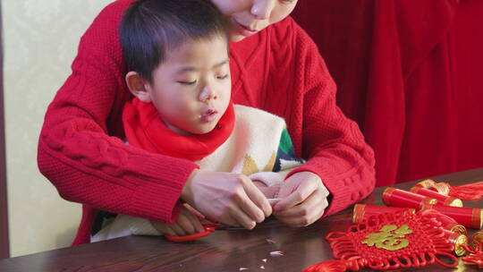 亚洲中国母子春节剪纸剪窗花红纸