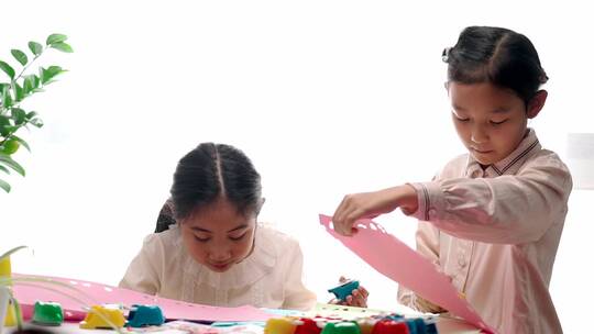 两名认真玩剪纸游戏的中国女孩升格