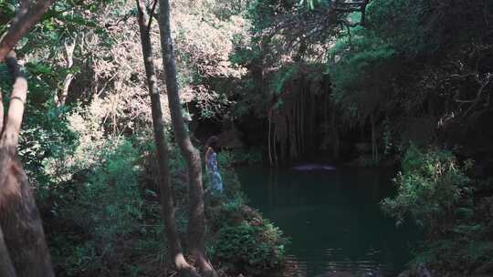 一个女人走向森林中的泻湖