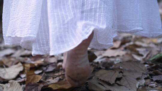 女孩赤脚走在满是落叶的地上4k视频素材