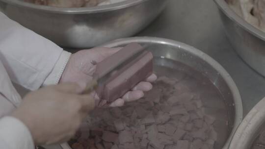 羊汤制作厨师在手掌中切割羊血豆腐中景LOG