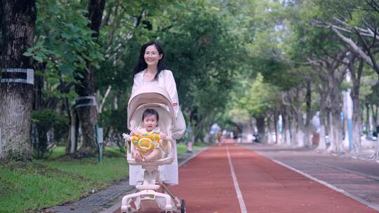 妈妈推着婴儿车带着宝宝在公园散步