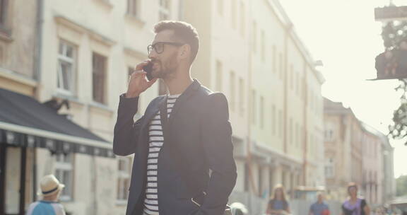 时尚男人站在旧城打电话