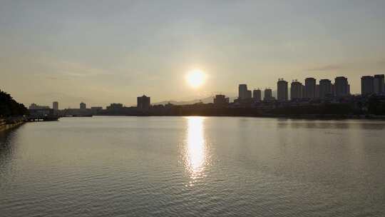 城市河畔夕阳余晖下的平静水面