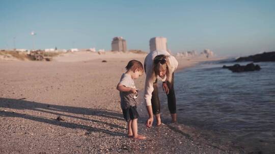 女人和她儿子在海捡石子