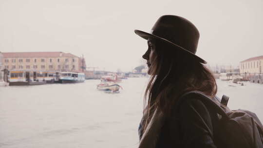 宁静年轻迷人的女性游客沿着繁忙的城市河流进行美丽的乘船游览