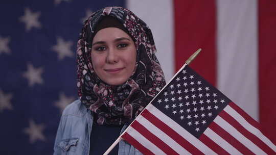 女人微笑着骄傲地举着美国国旗