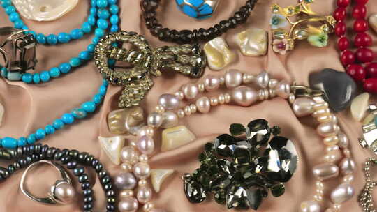水下米色丝绸背景上由宝石和珍珠制成的珠宝