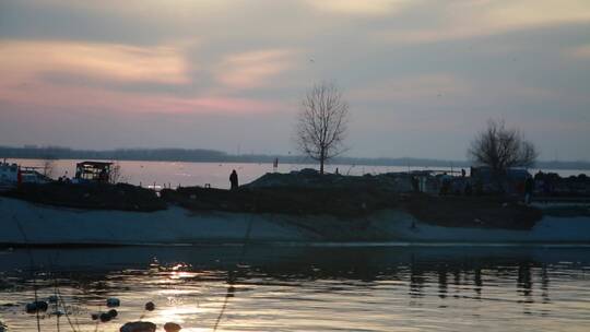 夕阳西下的湖边的人们