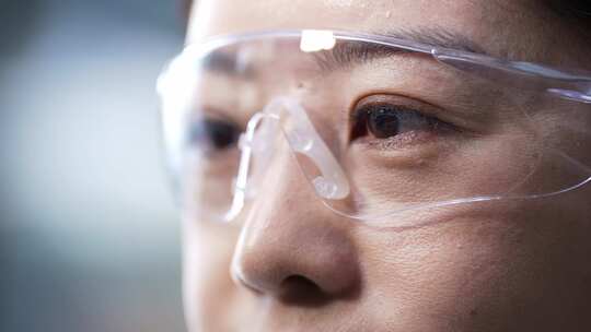 女性科研人员戴着护目镜在生物实验室做实验