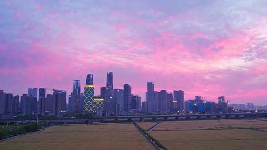 天空晚霞下的杭州城市建筑与麦田高铁航拍