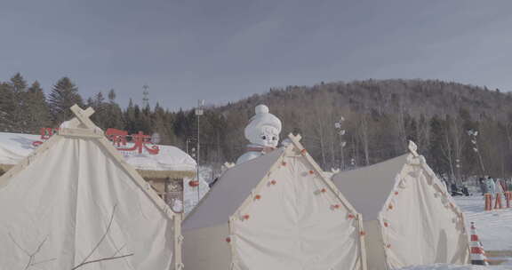 雪地上装饰喜庆的白色帐篷和雪人雕塑