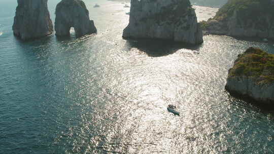 游艇在靠近法拉利奥尼岩石的第勒尼安海平静