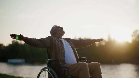 轮椅上的老人享受自由有特殊需要的男性微笑