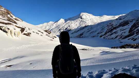 背着背包的人在雪山上行走