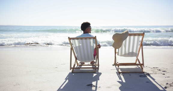 一个年轻的混血儿在沙滩椅上放松，面朝大海