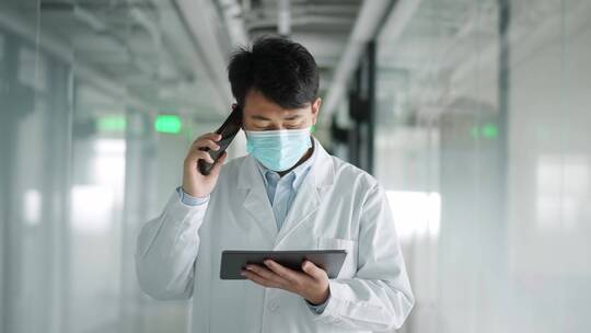 年轻医学科研人员走廊里使用平板电脑手机