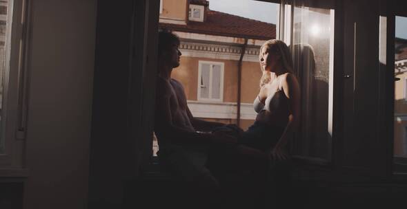 一对夫妇坐在阳台上沐浴日光