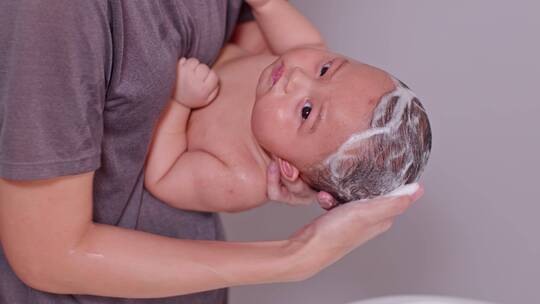 宝妈给刚出生的婴儿洗头视频素材模板下载