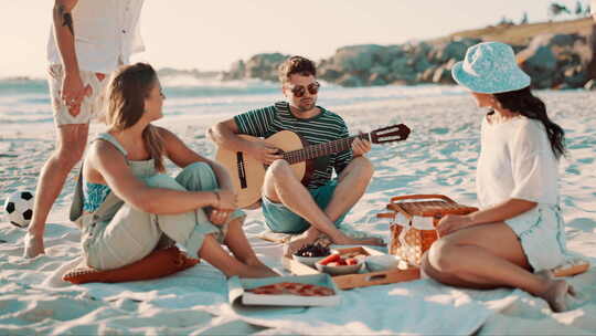 朋友们在沙滩上野餐，用吉他唱歌