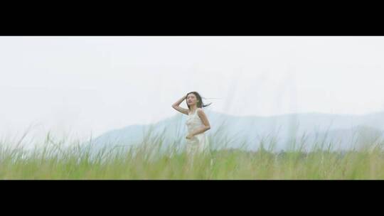白色连衣裙女子站在草地上视频素材模板下载