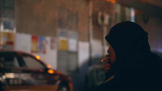 男子在街边抽烟蹲守独身女孩