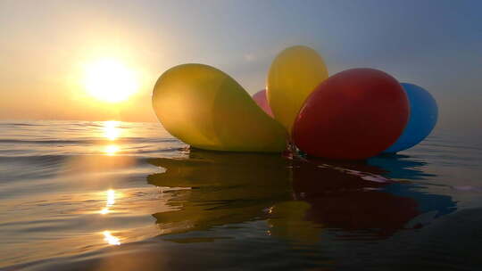 一束Airy五彩气球摇摆海浪阳光明媚的夏