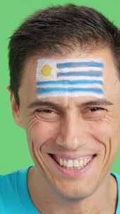 脸上画着乌拉圭国旗微笑的男人
