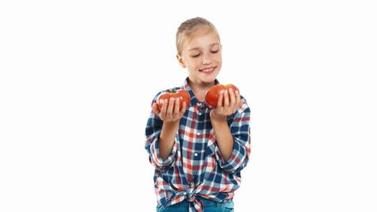 小女孩开心的拿着两个西红柿