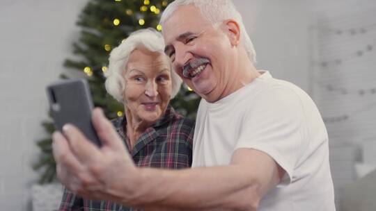 老年夫妻使用手机和子女视频通话