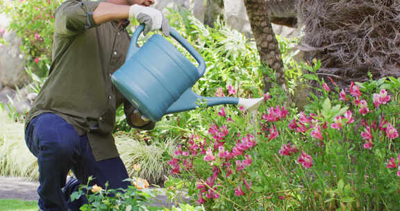 Biracial人园艺，用喷壶浇灌植物