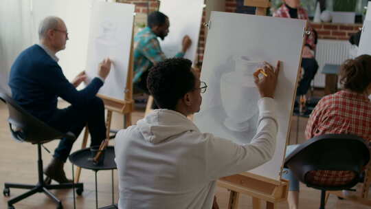 非裔美国学生用铅笔在画布上画花瓶模型