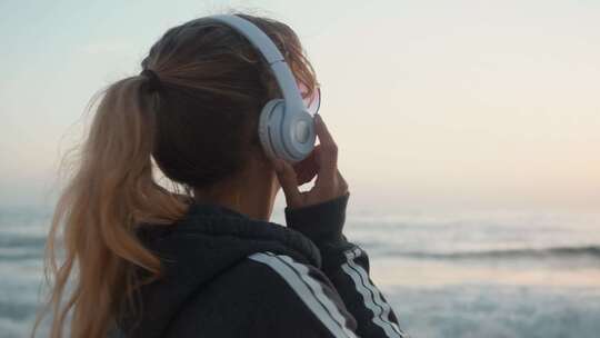 在沙滩上听音乐的女孩