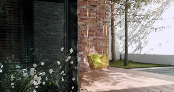 现代家居外观，配有柳条吊椅和郁郁葱葱的花