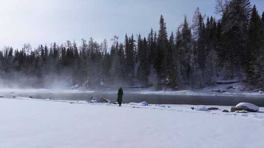 航拍新疆阿勒泰冬季喀纳斯游客在雪地上游玩