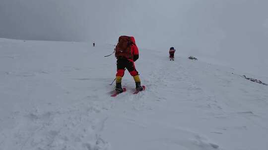 风雪天气中攀登慕士塔格峰雪山的登山队