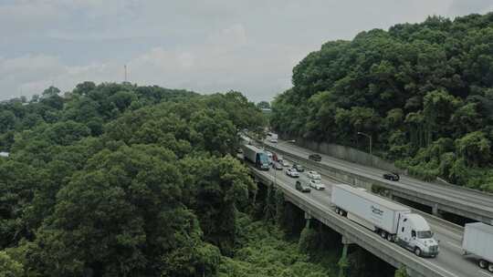 在郁郁葱葱的植被旁边的桥上跟踪拍摄汽车