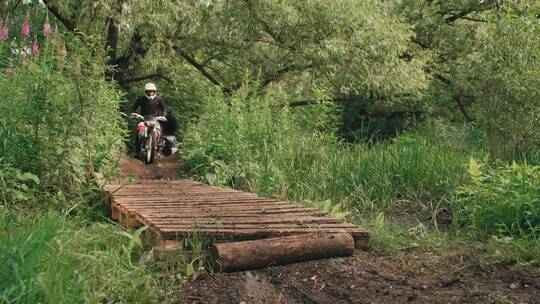 两个男人在森林的木桥上骑摩托视频素材模板下载