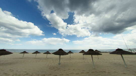 阴天时光流逝，美丽的热带海滩上的稻草伞