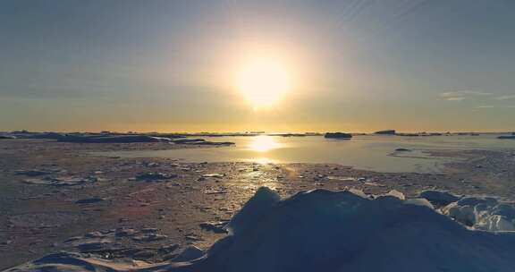 北极冬季景观上的彩色日落