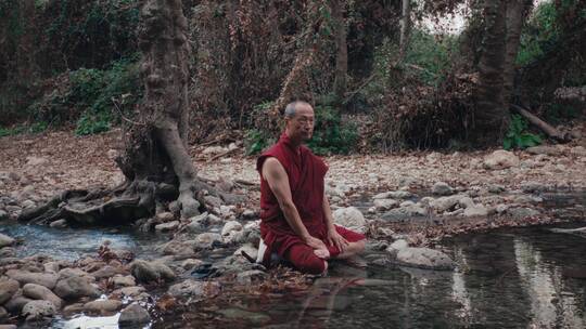 僧人坐在河边石头上视频素材模板下载