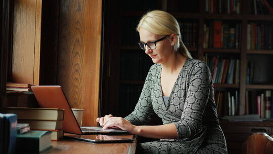 在图书馆用笔记本电脑办公的女人