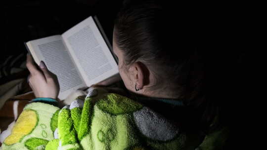 女人躺在沙发上看书