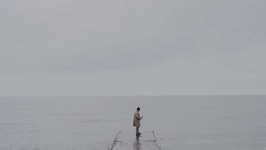 一个男人在木桥上用雨伞