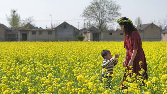 中国女性和小朋友在油菜花田地中玩耍