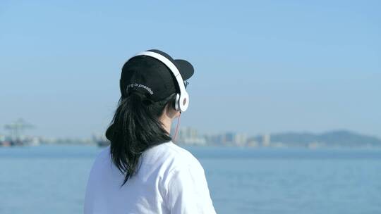 清新唯美女孩在江边听音乐背影视频素材