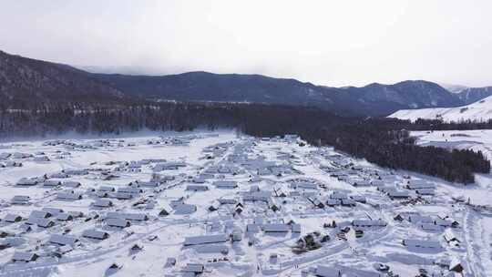 航拍新疆禾木雪景森林雪地小木屋禾木桥雪山